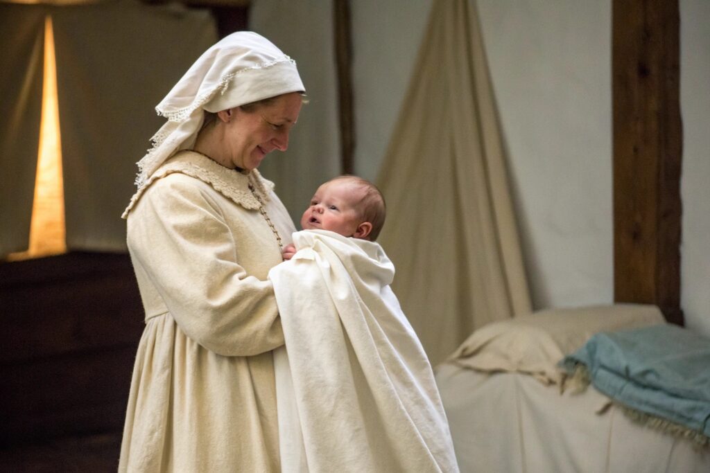 Historical depiction of a baby and caregiver