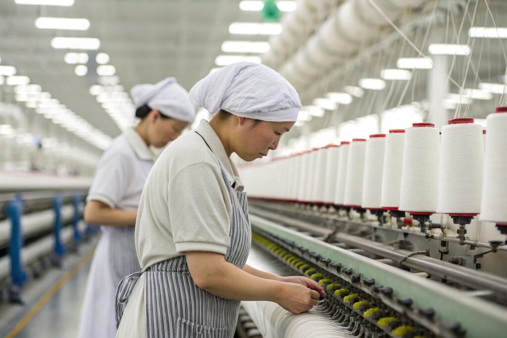 Worker at textile mill operating yarn machines