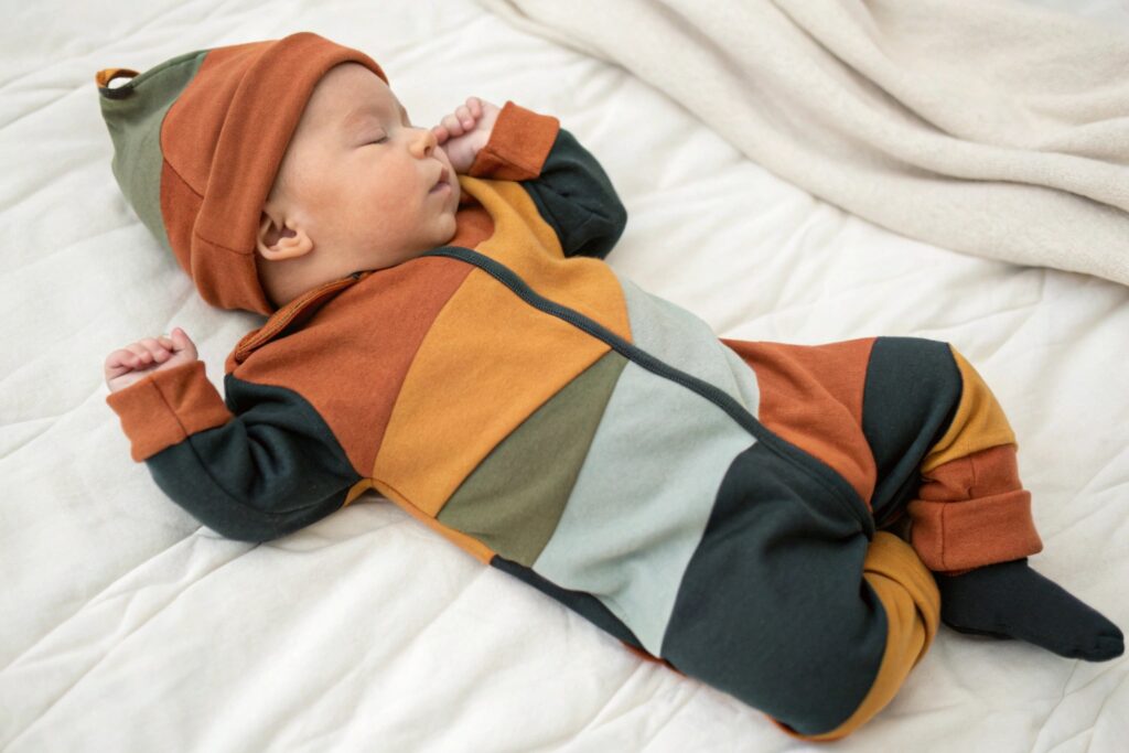 baby boy sleeping in a stylish color-blocked onesie with matching hat