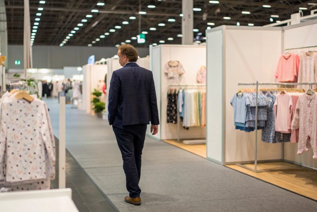 A person walking through a trade show, exploring kids' clothing displays