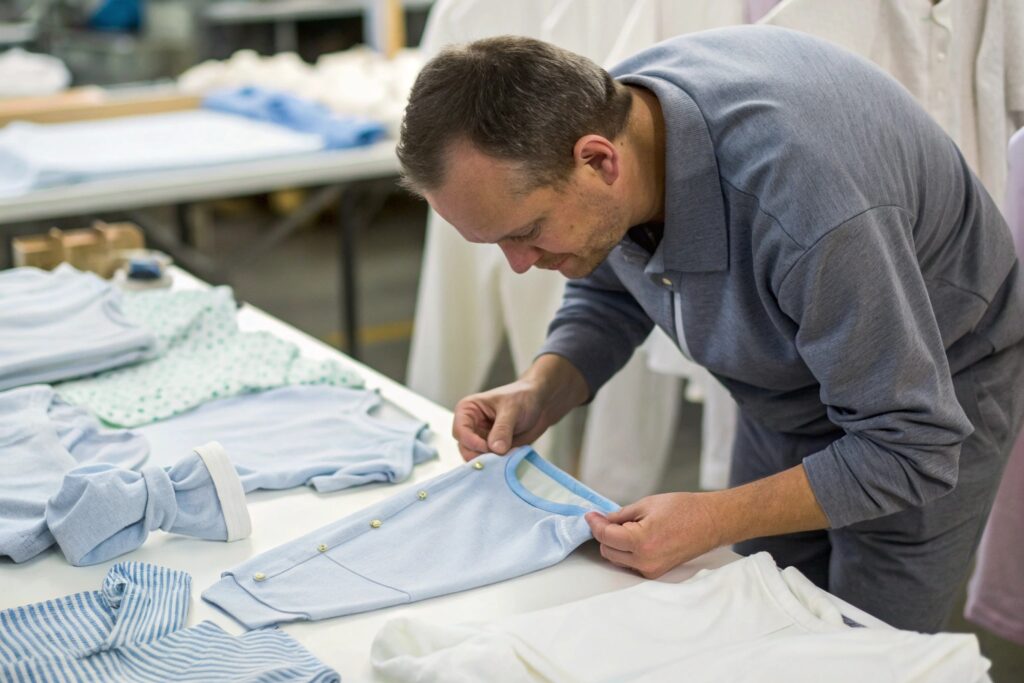 Business owner inspecting babywear