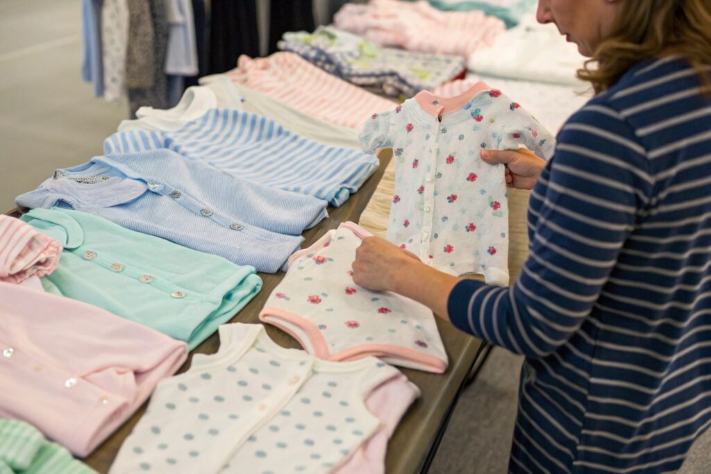 business owner reviewing children's clothing items at a trade show