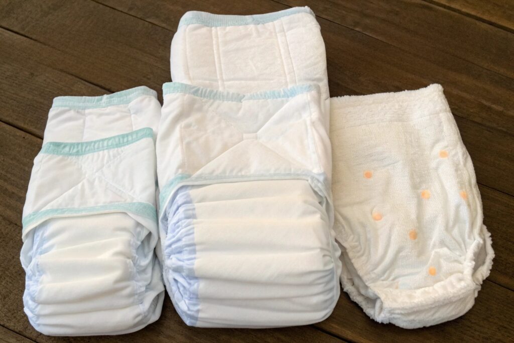 Two youth-sized diapers displayed side by side on wooden surface