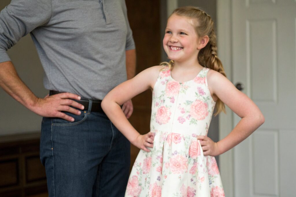 Smiling girl in floral dress posing confidently indoors