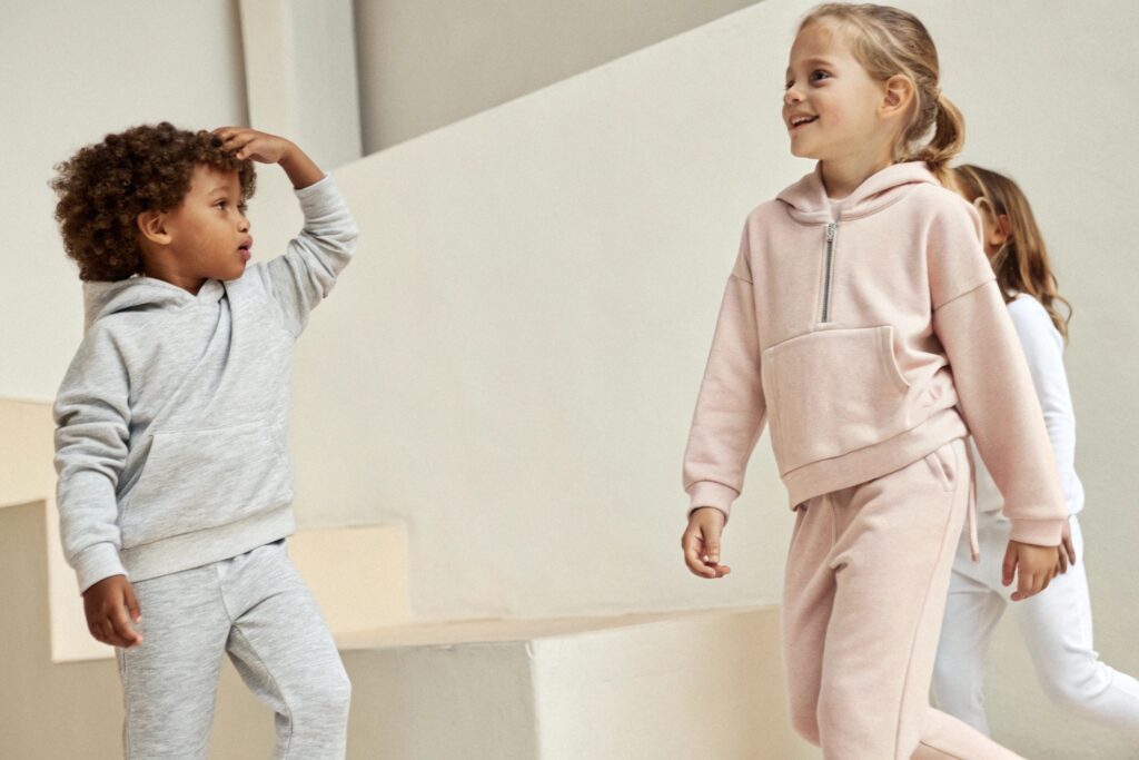 Children wearing modern casual sweatsuits in neutral tones