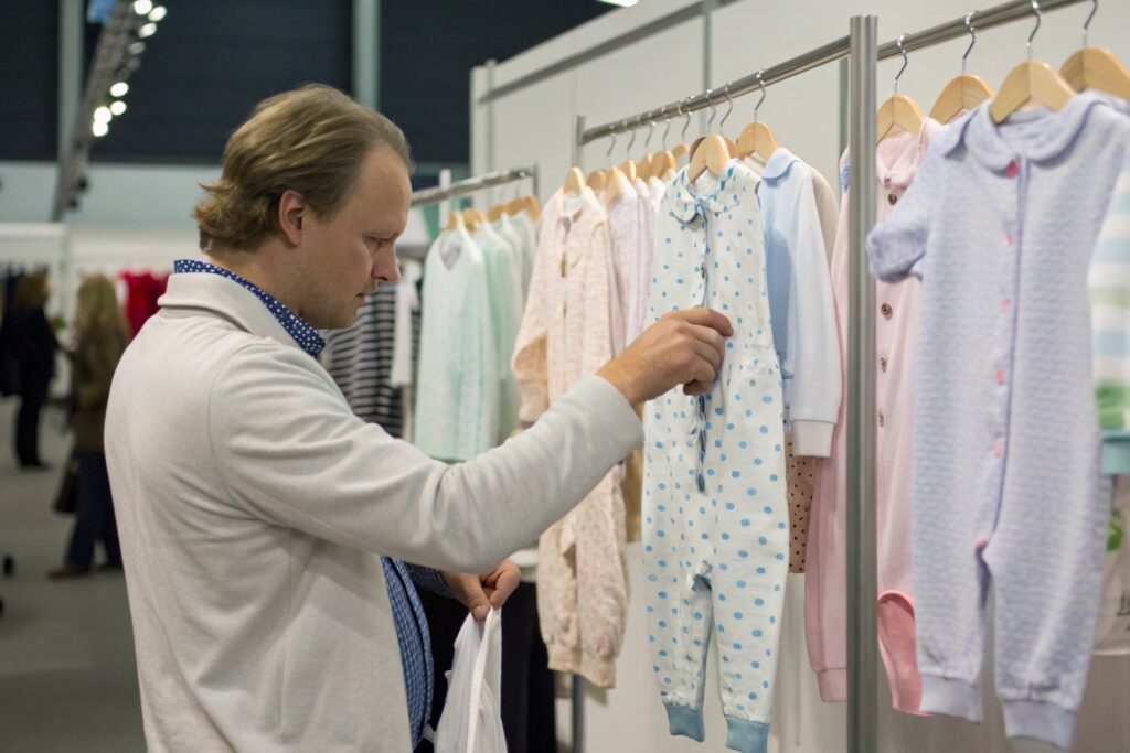 Buyer examining a display of kidswear at a trade fair
