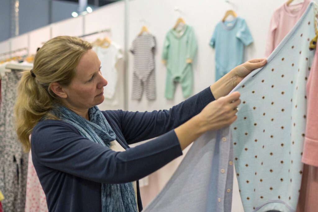 Buyer feeling the fabric of a kidswear sample at a trade show