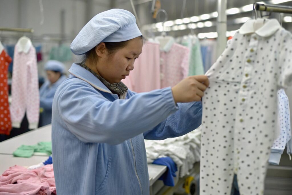 Factory worker assembling babywear products