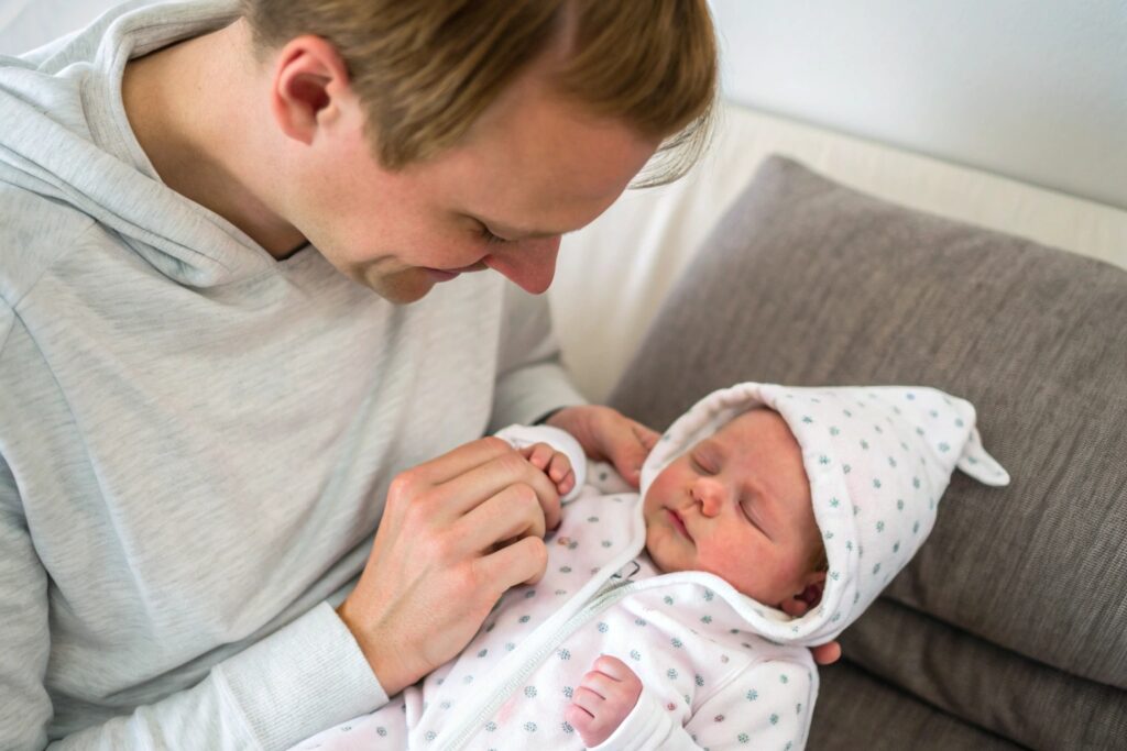 Parent dressing their newborn in a soft, non-toxic baby onesie