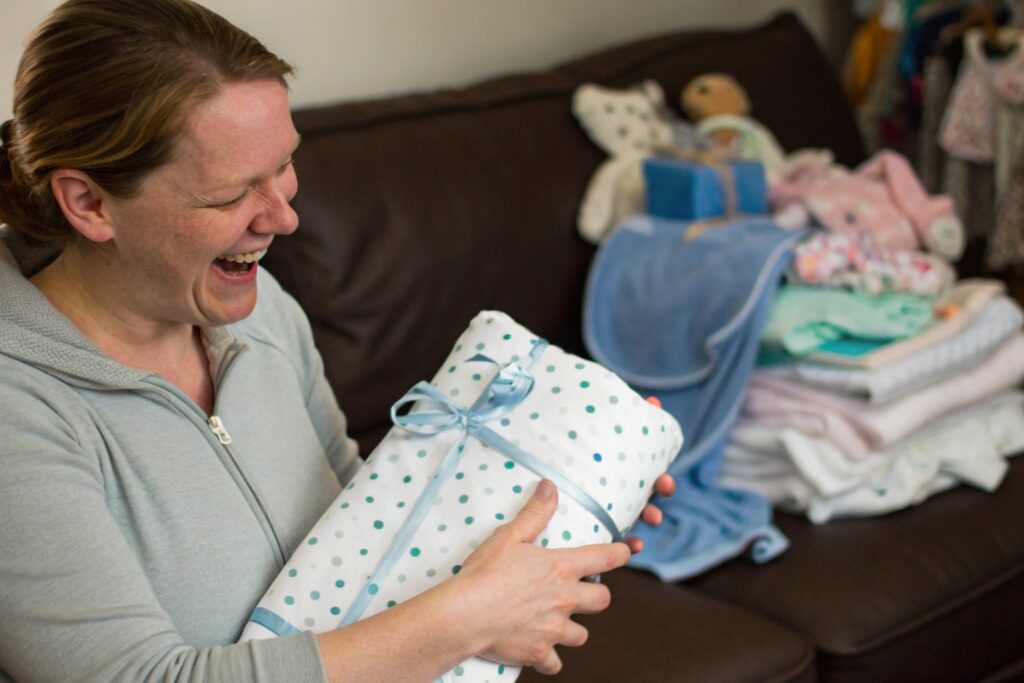 Parent receiving a personalized baby gift with a joyful expression