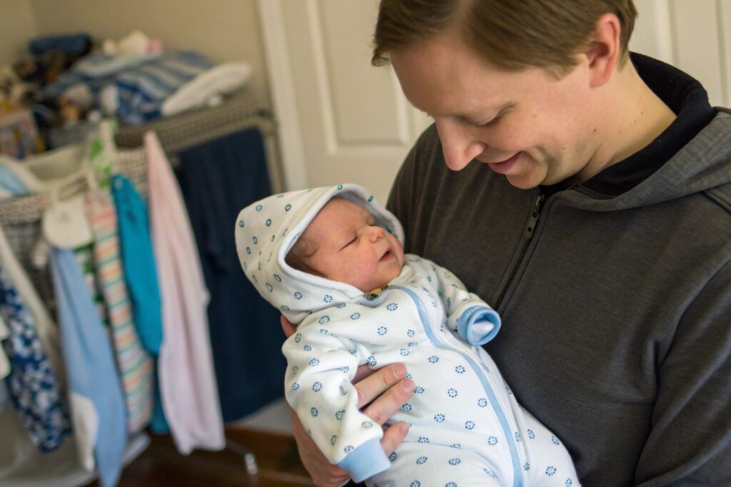 Parent sharing a photo with their newborn in a cozy hoodie