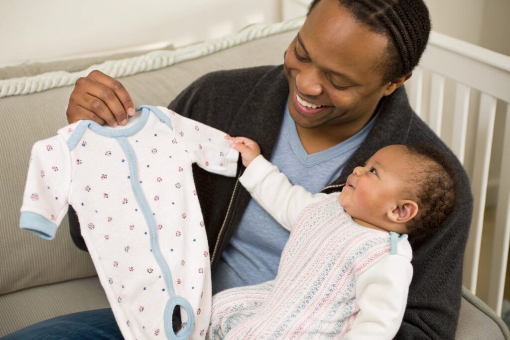 European Parent Smiling While Holding a Perfect Babywear Garment