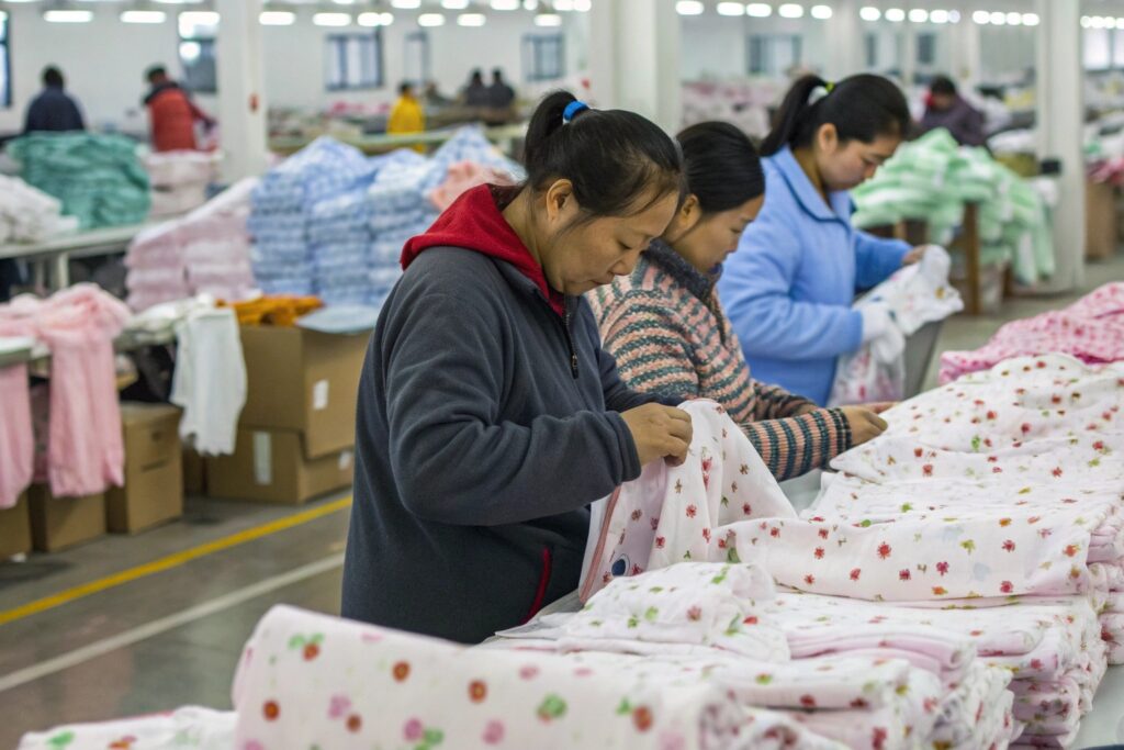 Warehouse worker organizing babywear items Warehouse worker organizing babywear items