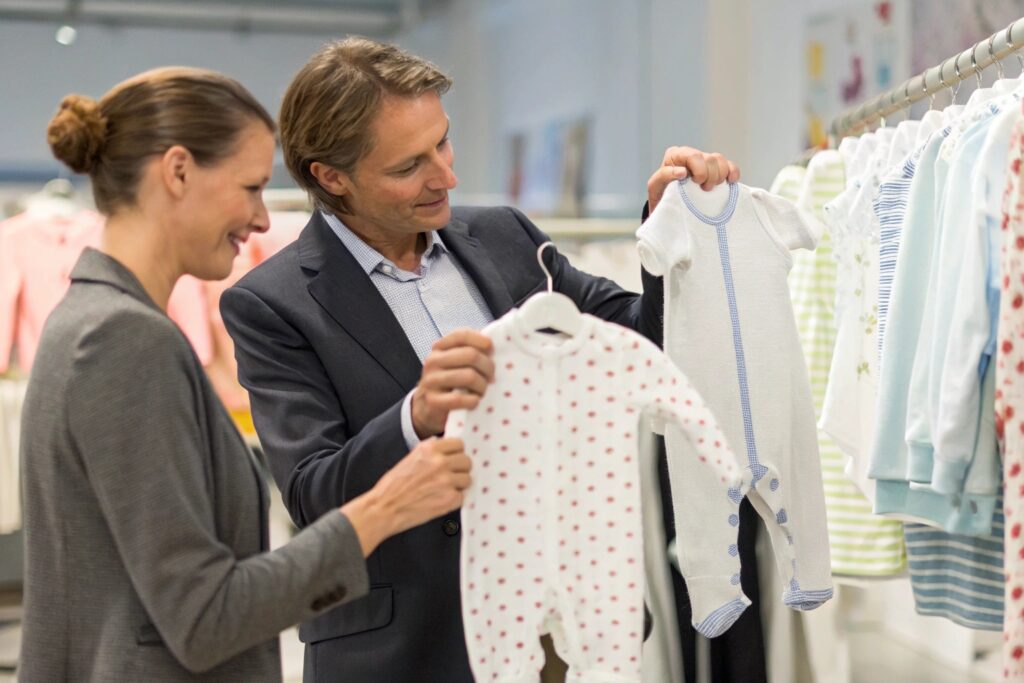 A business owner or expert showing baby clothing to a client