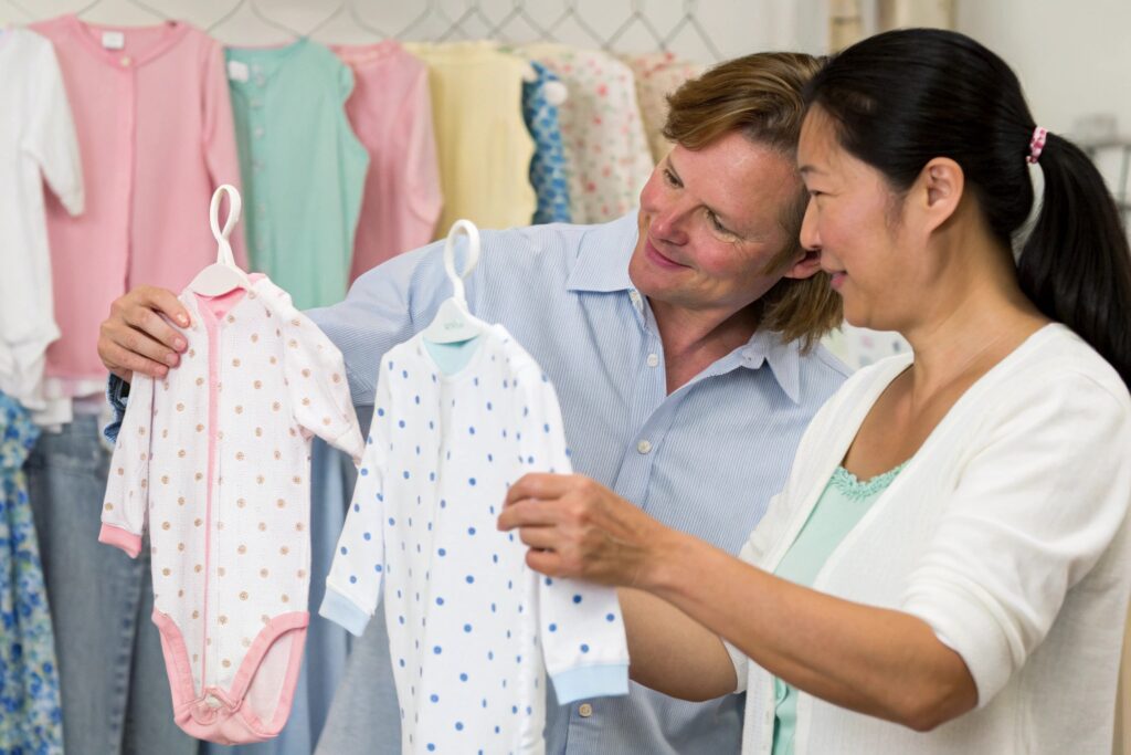 Fabric specialist reviewing babywear garments with business owner