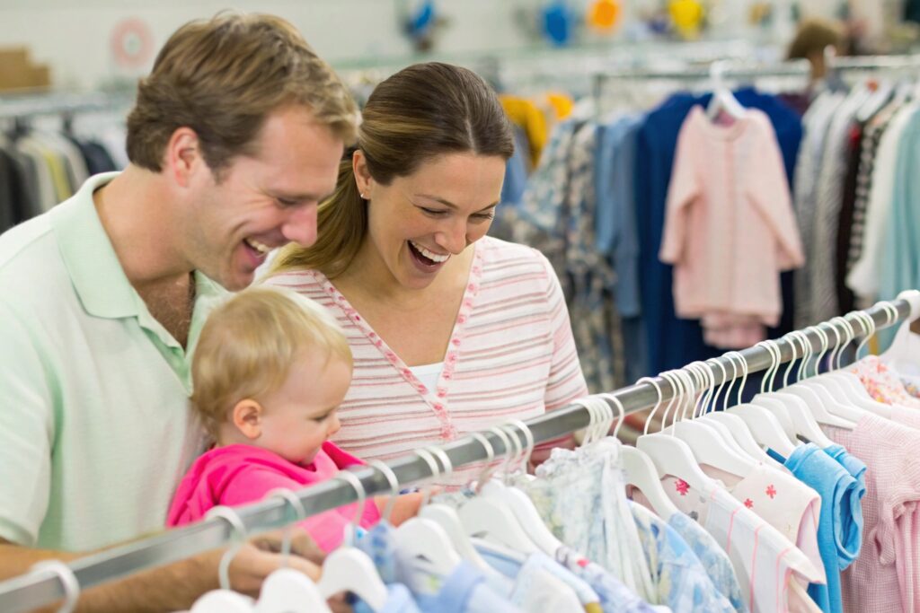 Family happily shopping at a clothing store for babywear