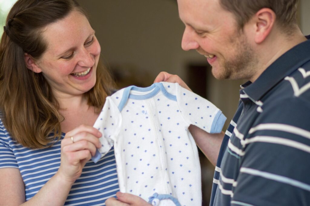 Parent joyfully receiving personalized babywear gift