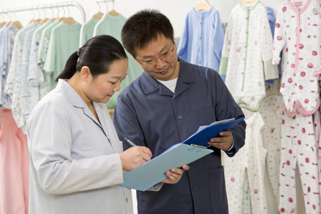 Business owner and quality control expert reviewing clothing