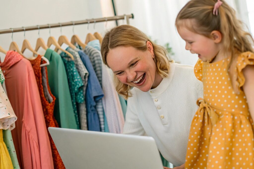 A parent shopping for stylish children's dresses online with their daughter