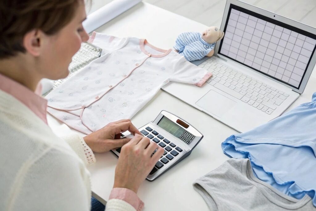 Business owner calculating inventory costs for babywear