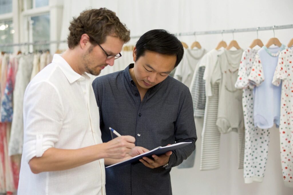 Designer and business owner reviewing babywear design in production