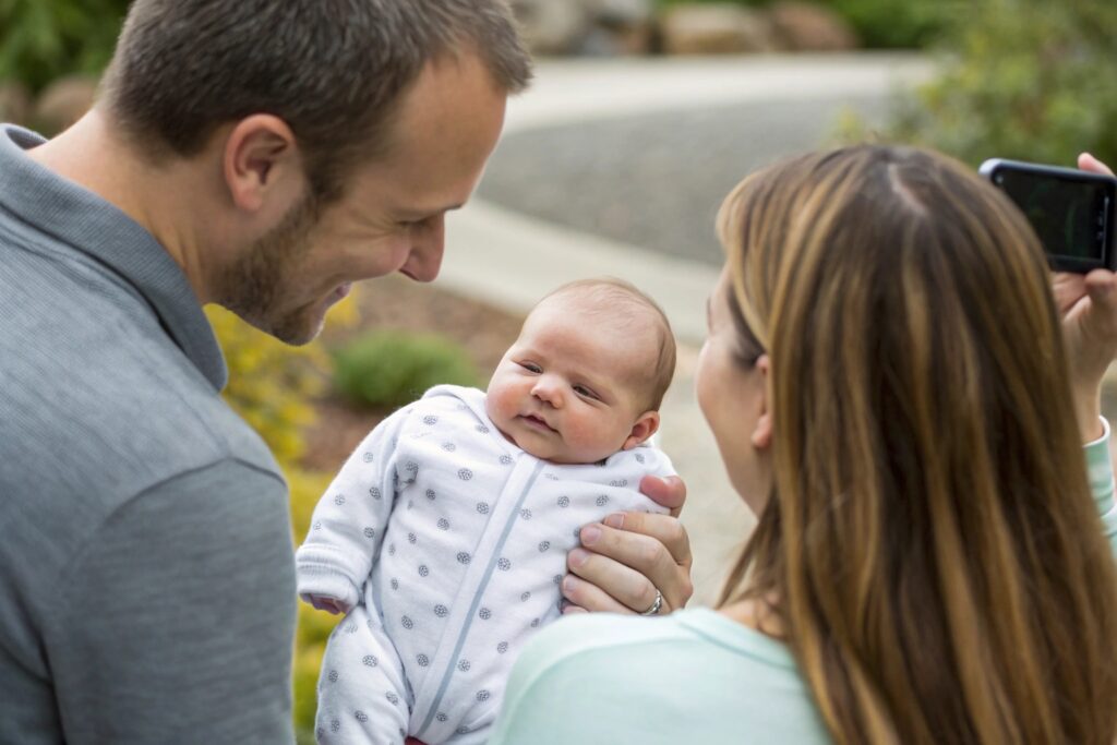 Parents taking a photo with their baby in a cute outfit
