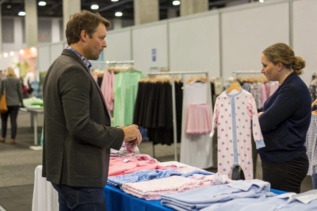 Business owner at a trade show discussing babywear
