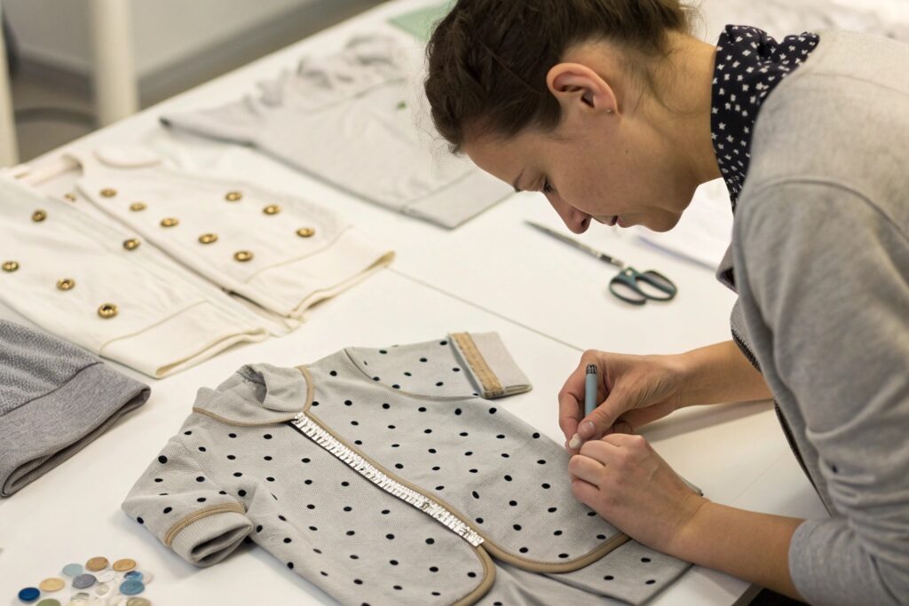 Designer marking fabric for baby clothes with a tape measure and fabric markers